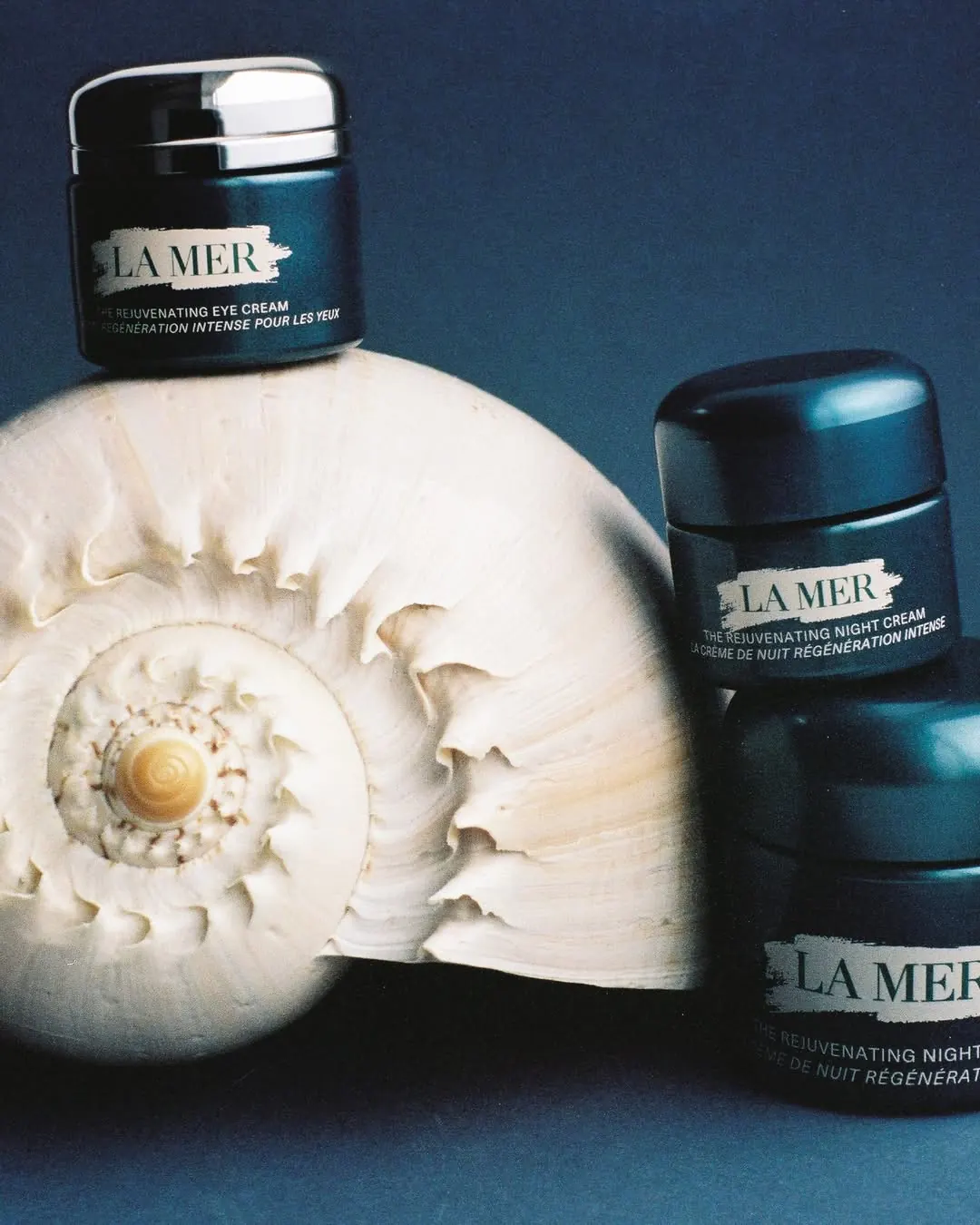 La Mer Rejuvenating Eye Cream jar with Rejuvenating Eye Tool applicator on a marine-inspired surface