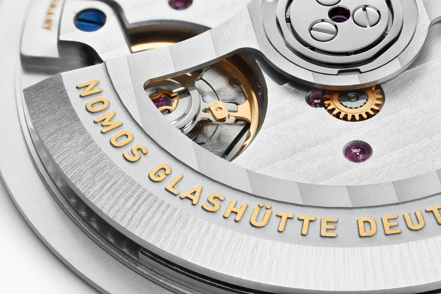 NOMOS DUW 6101 movement showing Glashütte ribbing three-quarter plate and thermally blued screws