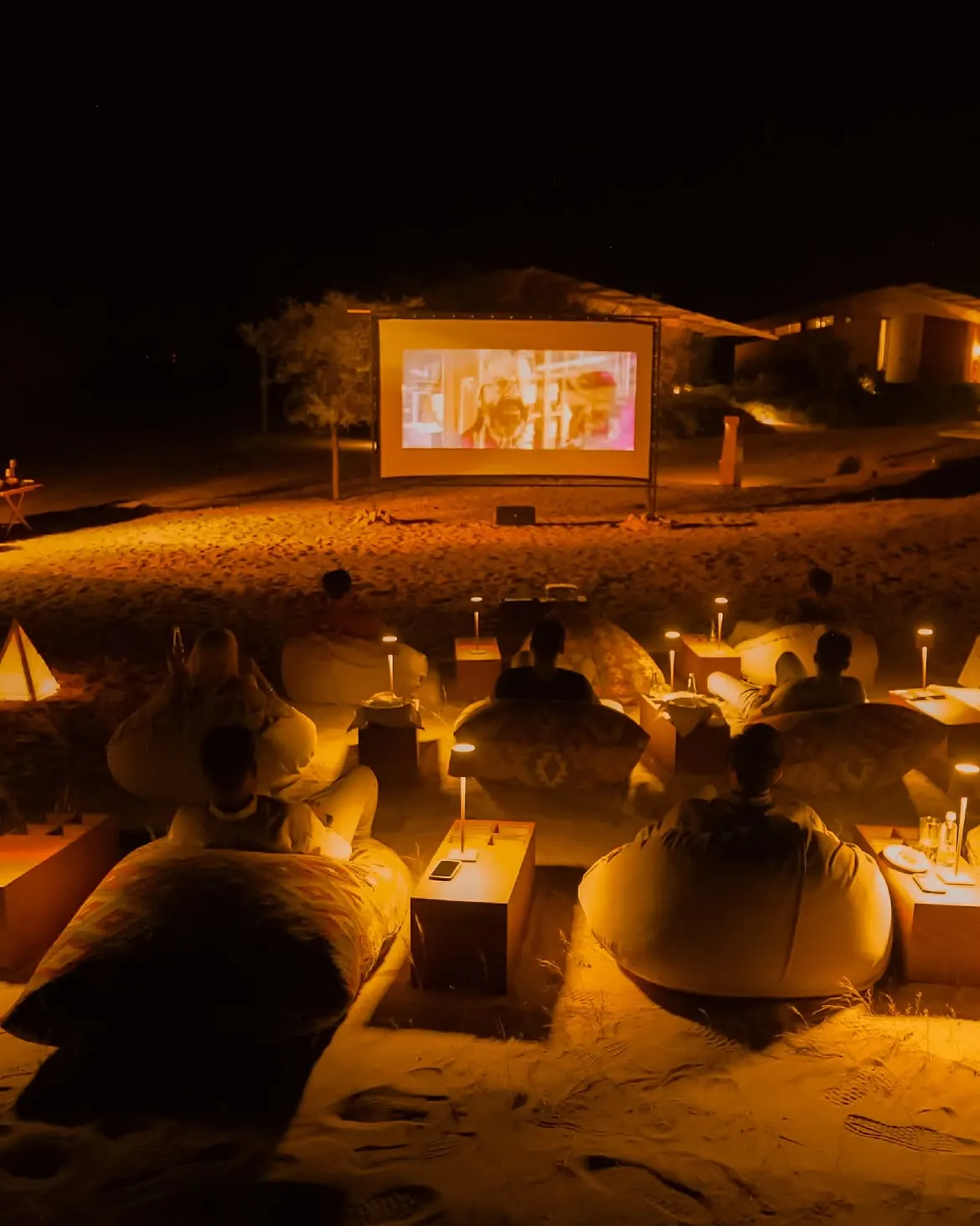 Open-air cinema screen set against the Tabuk desert dunes at Six Senses Southern Dunes The Red Sea under a star-filled sky