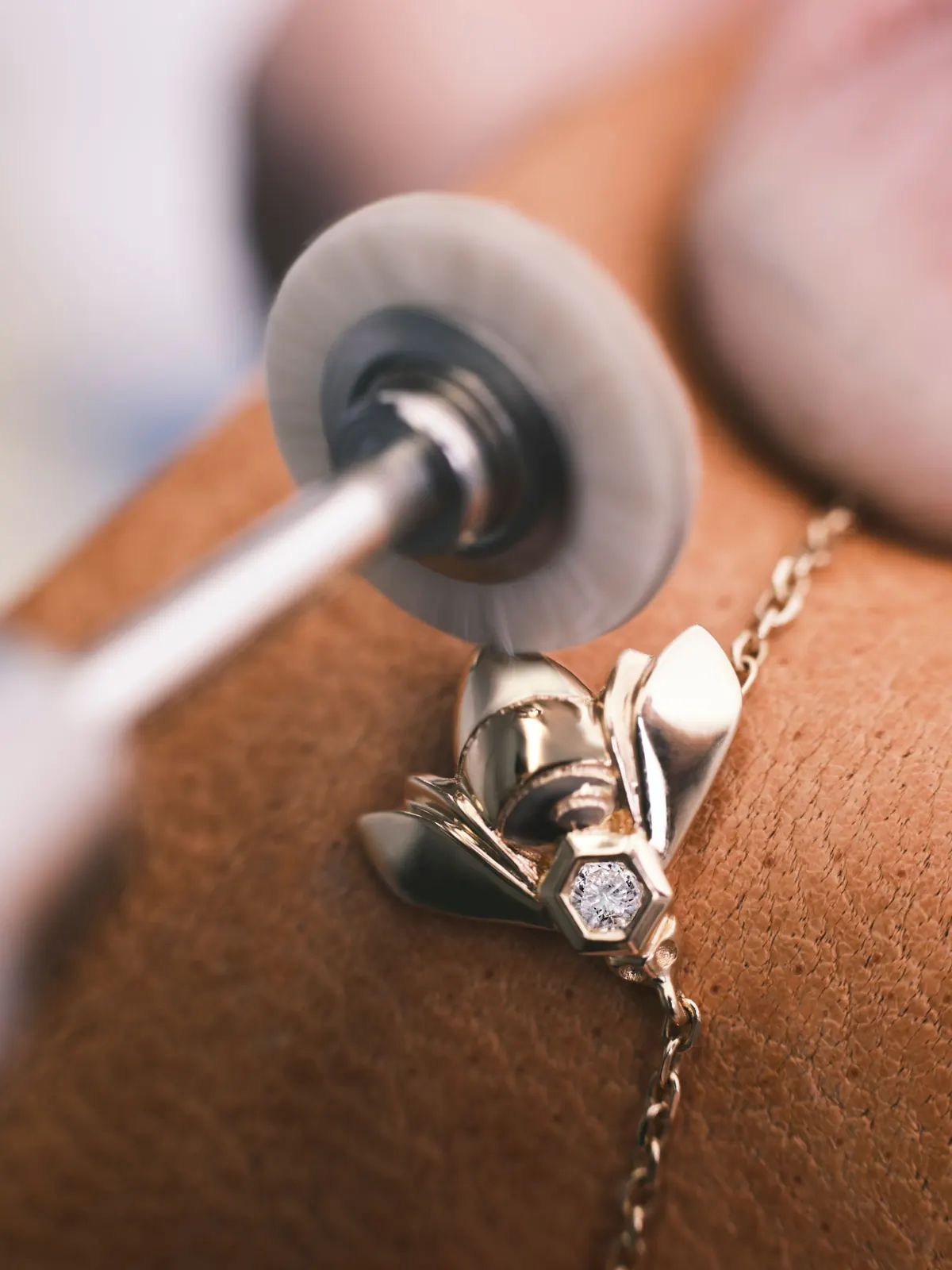 Close-up of the Bee de Chaumet pendant showing the honeycomb motif and single diamond in traceable gold