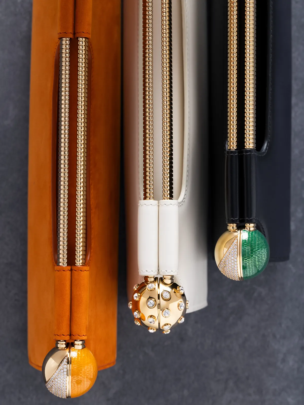Bvlgari Tubogas Spheres clutch in black calf leather with gold-finish brass handle and spherical ends