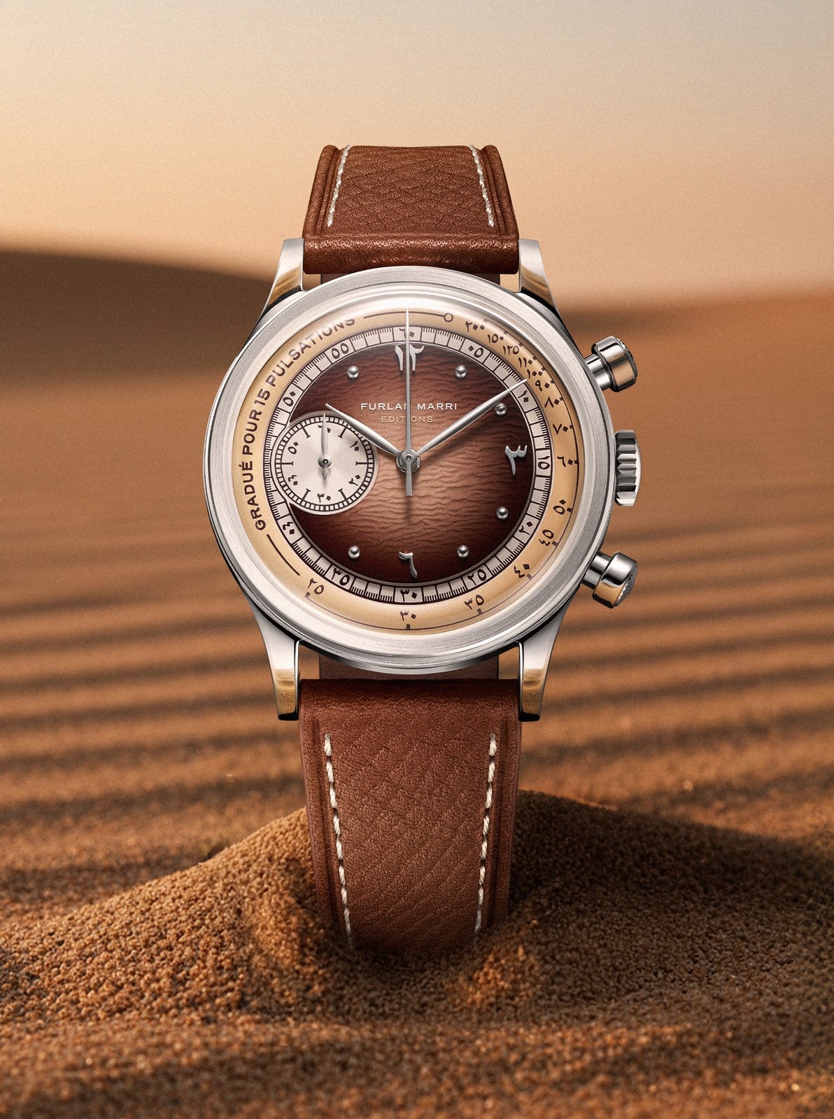 Furlan Marri Sahra Edition dial with Hindi-Arabic numerals and a pulsations scale, resting on Saudi desert sand