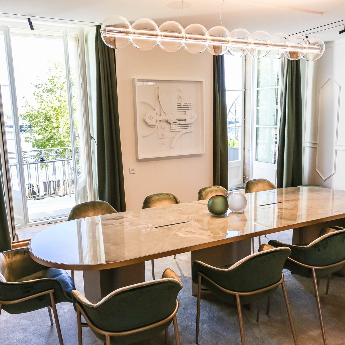 First-floor showroom of the Girard-Perregaux maison in Geneva with a long table and green chairs
