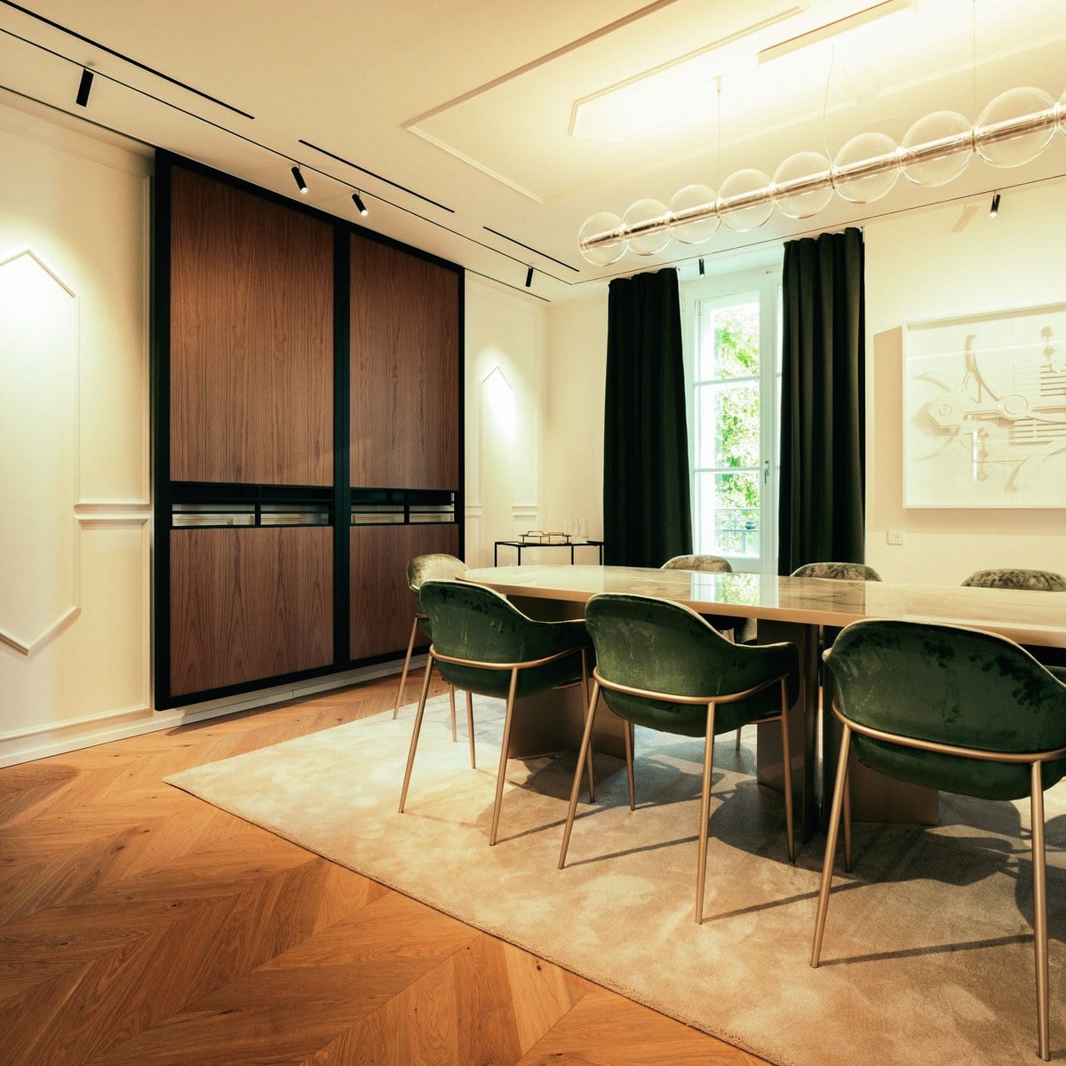 Salon of the Girard-Perregaux Geneva maison with green armchairs and a long table, official image