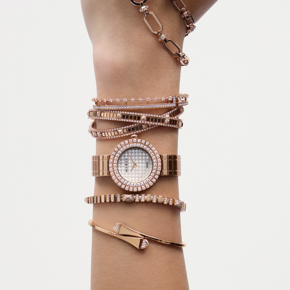 MARLI rose gold timepiece worn with a stack of diamond bracelets, official image