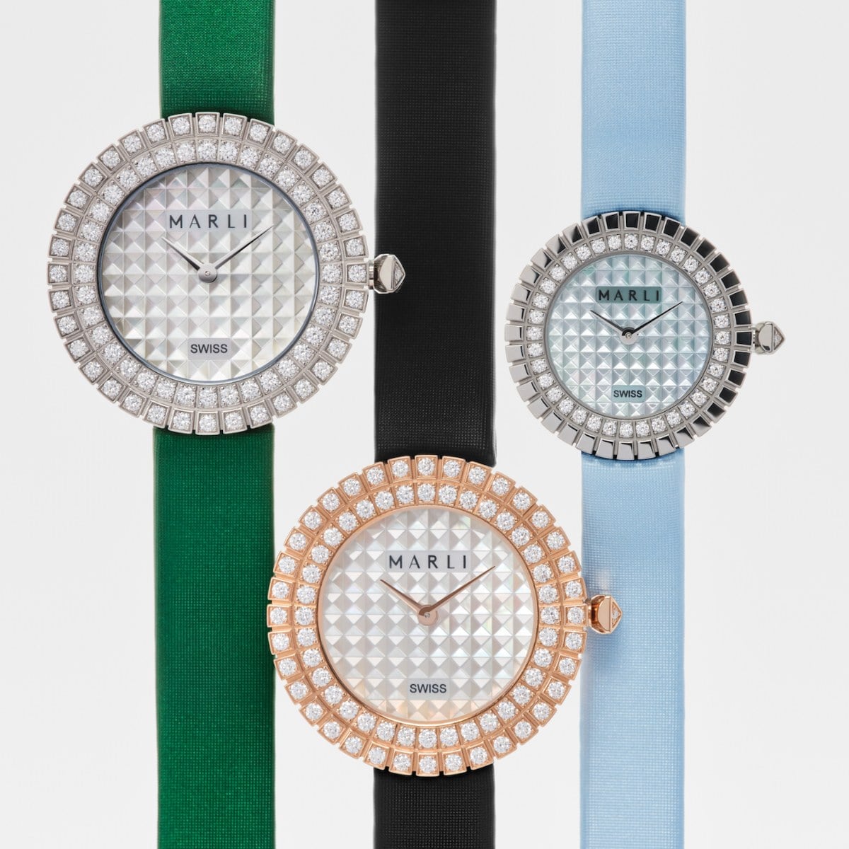 Three MARLI timepieces with diamond-set bezels on green, black and light-blue satin straps, official image