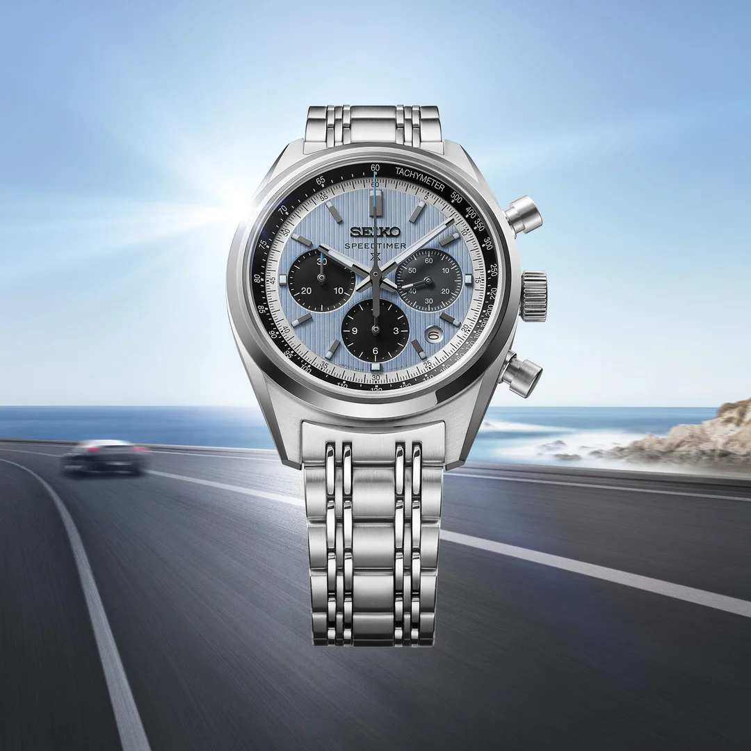 Seiko Prospex Speedtimer mechanical chronograph with ice-blue dial and steel bracelet on a coastal road backdrop