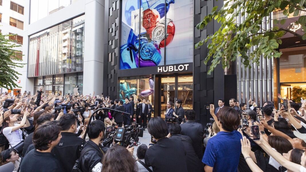 Jung Kook and Julien Tornare at the entrance of the Hublot Ginza Boutique in Tokyo, greeted by a crowd of fans