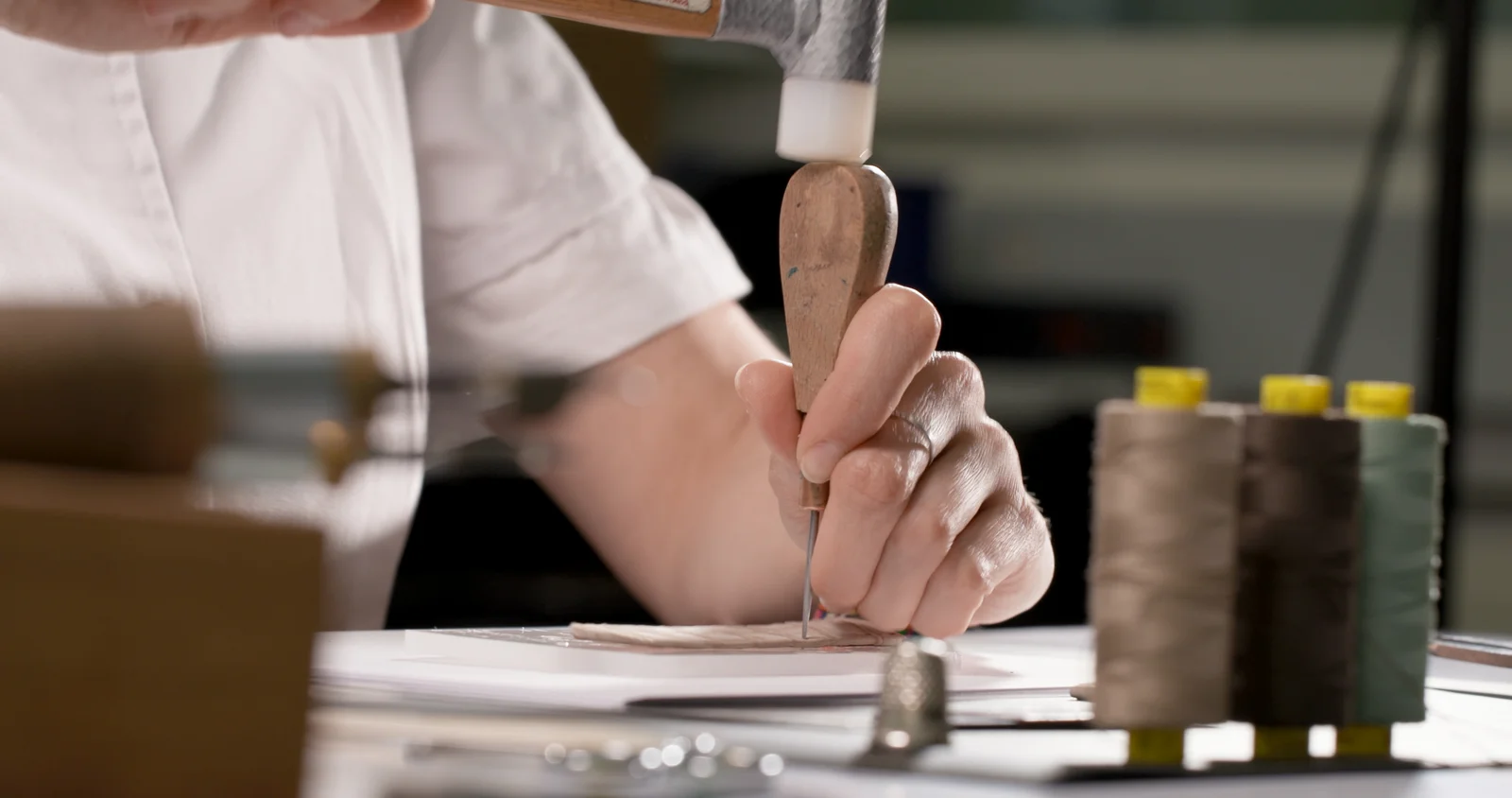 Artisan stitching the Akoya Grey nubuck alligator strap by hand in the punto a mano tradition