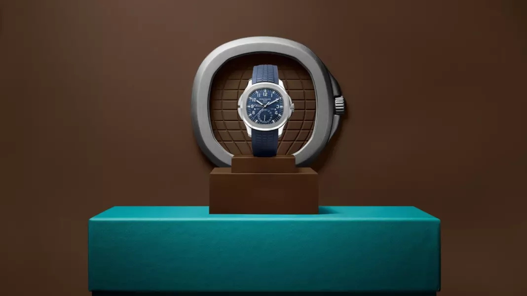 Patek Philippe 5164G-001 - Sotheby's Patek Philippe Aquanaut Travel Time 5164G-001 with a blue dial and strap, presented on a pedestal