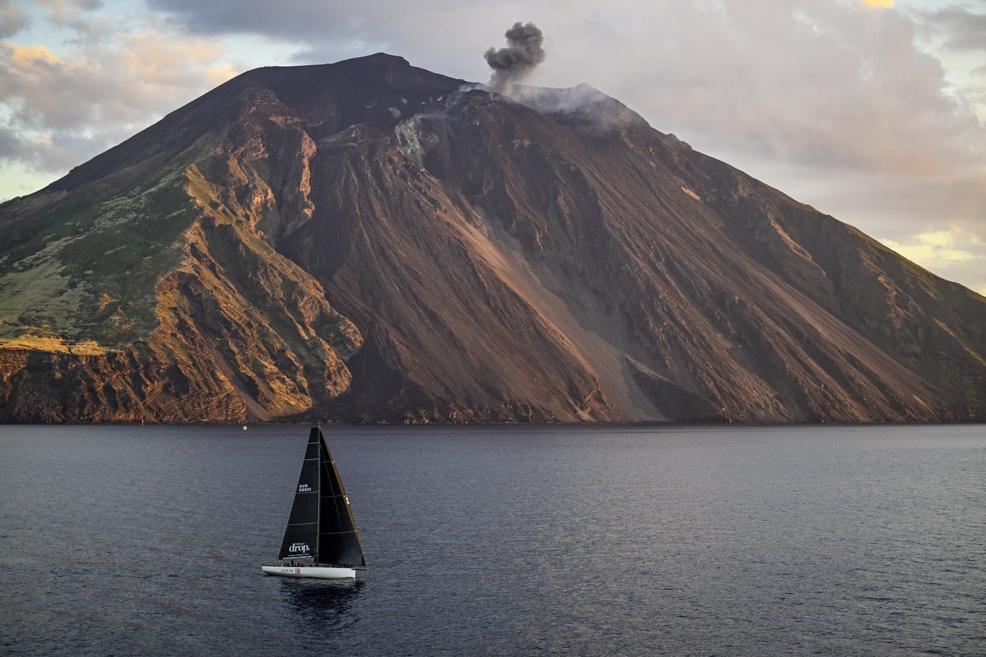A yacht of the Rolex Middle Sea Race passing the volcanic island of Stromboli